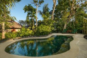 a pool in a yard with a table and chairs at Mimpi Resort Menjangan in Banyuwedang