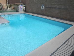 a swimming pool with blue water in a building at Little Boy Blue Motel in Anaheim