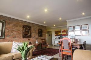 a living room with a couch and a brick wall at Hillside Guesthouse Umhlanga in Durban
