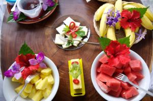 einen Holztisch mit Schalen mit Früchten und Teller mit Lebensmitteln in der Unterkunft Selva Bananito Lodge in Westfalia