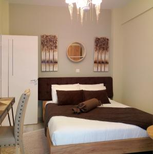 a bedroom with a large bed and two paintings on the wall at Kosmima deluxe Apt.(must) in Thessaloniki