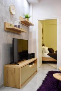 a living room with a flat screen tv on a wooden cabinet at Kosmima deluxe Apt.(must) in Thessaloniki