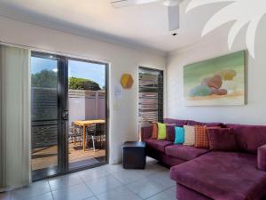 een woonkamer met een paarse bank en een tafel bij Aqua Apartment 3 in Blueys Beach