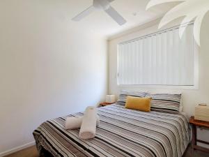 a bedroom with a bed with a large window at Aqua Apartment 3 in Blueys Beach
