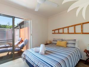 een slaapkamer met een bed en een balkon bij Aqua Apartment 3 in Blueys Beach