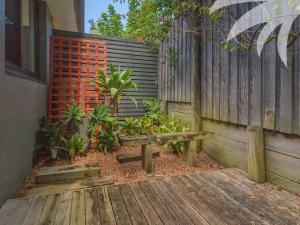a wooden bench sitting next to a fence at Aqua Apartment 4 in Blueys Beach