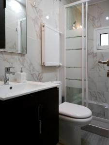 La salle de bains est pourvue de toilettes, d'un lavabo et d'une douche. dans l'établissement Kosmima deluxe Apt.(must), à Thessalonique