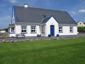 una casa bianca con una porta blu e un cortile di Nellie Dee's - Room Only a Doolin