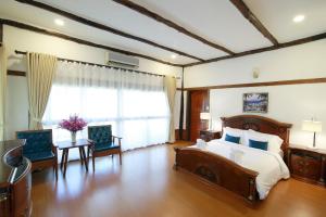 a bedroom with a large bed and a large window at E-outfitting Valley Resort in Chiang Mai