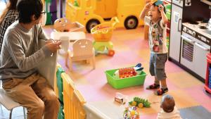 a couple of children playing in a toy kitchen at Hotel Ocean (Kokusai-Dori) in Naha
