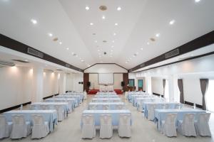 a large room with white tables and white chairs at E-outfitting Valley Resort in Chiang Mai