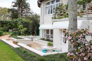 una casa con patio y un árbol en Lexden Guesthouse en Pietermaritzburg