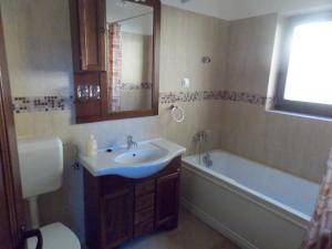 een badkamer met een wastafel, een bad en een toilet bij Pensiunea Jazmin in Zetea +49 foto's