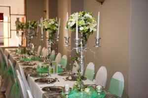 una mesa larga con flores verdes y blancas. en Le Grand Chateau Hotel en Parys
