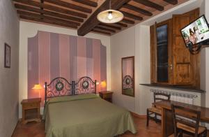 a bedroom with a green bed and a tv at B&B Villa Pardi Lucca in Lucca