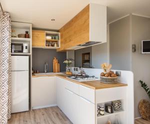 a kitchen with white cabinets and a counter at Camping Le Marqueval in Pourville-sur-Mer