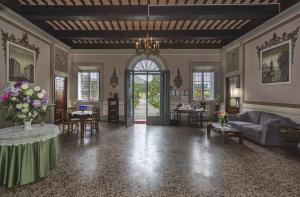 een woonkamer met een bank en een tafel met bloemen bij B&B Villa Pardi Lucca in Lucca