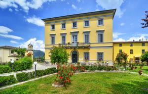ein gelbes Gebäude mit einem Garten davor in der Unterkunft B&B Villa Pardi Lucca in Lucca