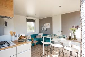 a kitchen and living room with a table and chairs at Camping Le Marqueval in Pourville-sur-Mer