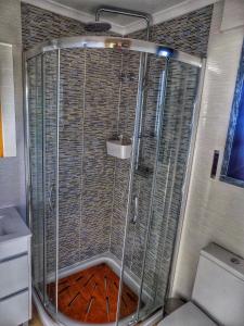 una doccia con una porta in vetro in un bagno di Villa Peponi a Ericeira Altre 23 foto