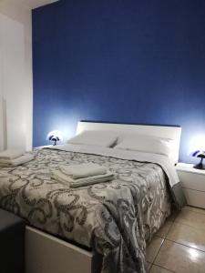Schlafzimmer mit einem Bett mit blauer Wand in der Unterkunft Catania House in Catania