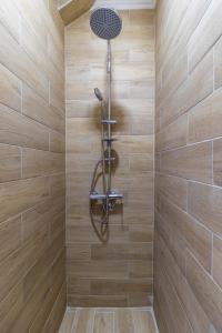 una ducha con cabezal de ducha en una pared de madera en HOUSE OF SURPRISE, en Užice