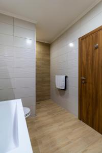 een badkamer met een toilet en een houten deur bij HOUSE OF SURPRISE in Užice