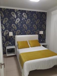 a bedroom with a bed with a blue and gold wallpaper at Apartamento Canteras Gran Canaria in Las Palmas de Gran Canaria