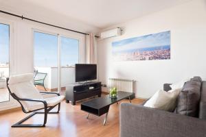 ein Wohnzimmer mit einem Sofa und einem TV in der Unterkunft Sagrada Familia Attic - Terrace Bcn Views in Barcelona