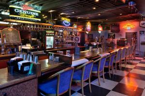 un bar con una fila de sillas azules en un restaurante en Red Lion Hotel Kelso en Kelso