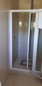 ダーバンにあるRoyal Ushaka Durban Northのバスルーム(ガラスドア付きのシャワー付)