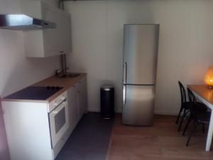 eine Küche mit einem Kühlschrank aus Edelstahl und einem Tisch in der Unterkunft Appartment Emosson 2 in Finhaut