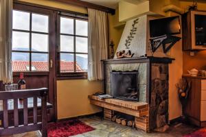 a living room with a fireplace and a window at Dio Studios in Arachova