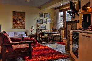 a living room with a bed and a kitchen with a table at Dio Studios in Arachova