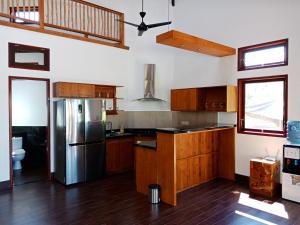 a kitchen with wooden cabinets and a stainless steel refrigerator at Samari Hill Villa in Buleleng