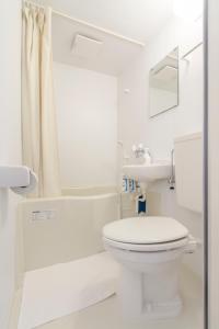 a white bathroom with a toilet and a sink at Dwell Urban 7B in Tokyo