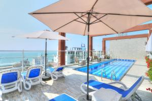 una piscina con sillas y sombrillas y una piscina en Morven Hotel Colombo, en Colombo