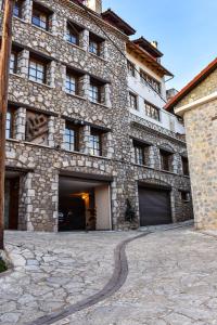a large stone building with two garage doors at Dio Studios in Arachova