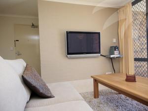 a living room with a flat screen tv on the wall at Oceanside 17 Breezes in Blueys Beach