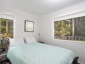 1 dormitorio blanco con 1 cama y 2 ventanas en Reflections, en Smiths Lake