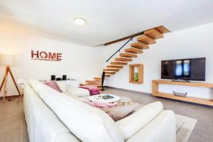 ein weißes Wohnzimmer mit einem weißen Sofa und einem TV in der Unterkunft Villa Marron in Veprinac