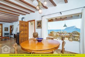 a dining room with a table and a view of the ocean at SolHabitat Villa Papavents in Benissa