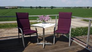 two purple chairs and a table with a vase of flowers at Haus Schaumburger Land in Volksdorf