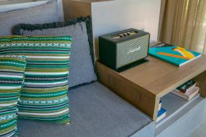 a bedroom with a bed with a table and a radio at Ekies All Senses Resort, a Member of Design Hotels in Vourvourou