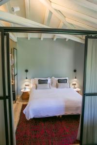a bedroom with a large white bed and two lamps at Ekies All Senses Resort, a Member of Design Hotels in Vourvourou