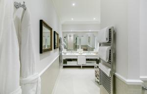 a white bathroom with a sink and a mirror at Bellevue Syrene in Sorrento