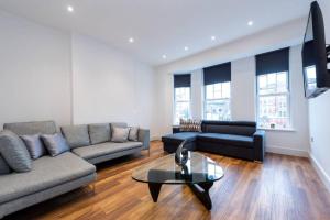 uma sala de estar com dois sofás e uma mesa de centro em Spacious and Luxurious London Apartment (MHB352) em Londres