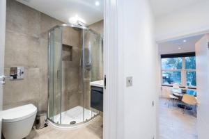 uma casa de banho com um chuveiro, um WC e um lavatório. em Spacious and Luxurious London Apartment (MHB352) em Londres