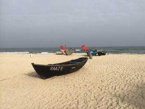 a black boat sitting on a sandy beach at Ostsee Strandhaus Seerobbe in Baabe