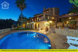 a villa with a swimming pool at night at SolHabitat Villa Big Blue in Benissa